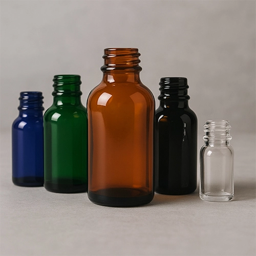 Colorful dropper dispensing bottles in amber, blue, green, black, and clear glass by Redex Glass.